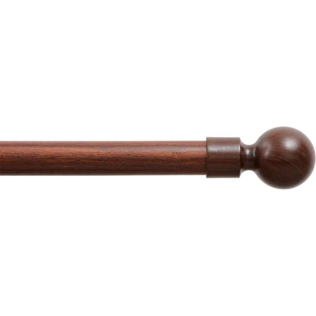 Wooden curtain rod with round finial for window treatment.