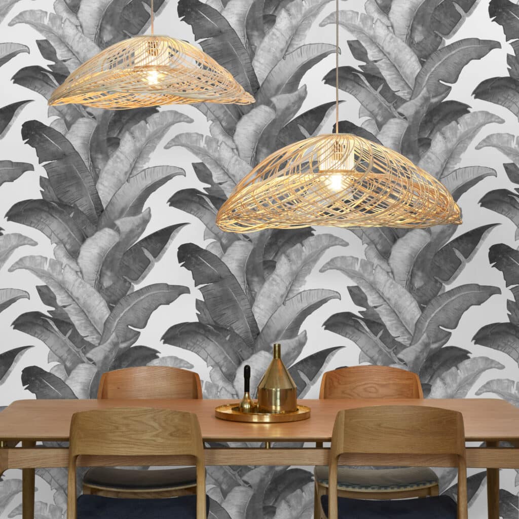 Decorative banana leaf wallpaper with modern pendant lighting in dining area.