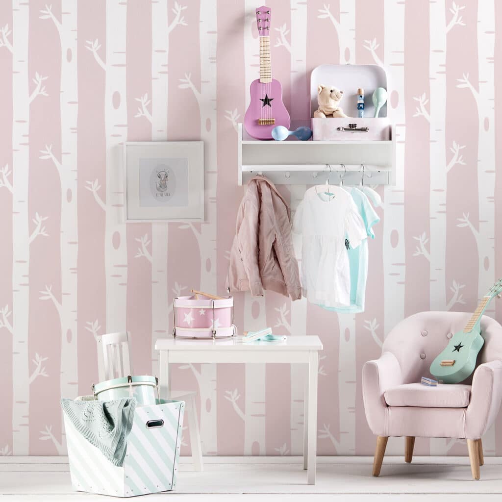 Kids room with pink birch tree wallpaper, toys, and cozy furniture.